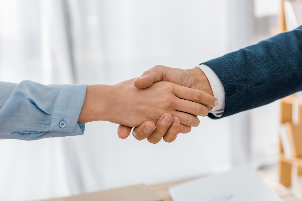 woman and man shaking hands in business